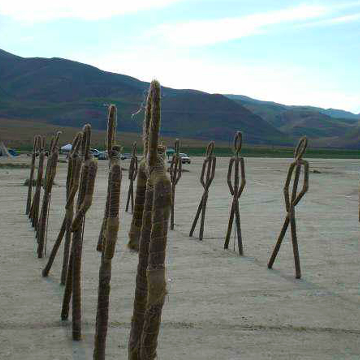Field of woven human effigy sculptures in a desert lake bed